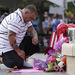 A man at a prayer vigil for victims of Friday's mass shooting at a movie theater in Aurora, Colo. pauses after placing items at a memorial display, Sunday, July 22, 2012. 