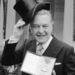 British actor Donald Sinden doffs his topper outside Buckingham Palace, London, on March 20, 1979, as he shows the CBE he received at the Investiture held by Queen Elizabeth II at the palace. (AP Photo/Harris)