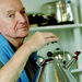 In this Oct. 21, 2003 file photo, architect and designer Michael Graves poses with a teapot he designed at his studio in Princeton, N.J. Graves, who designed modern and whimsical postmodern structures and later household goods sold at Target stores has died. He was 80 years old. (AP Photo/Daniel Hulshizer, file)